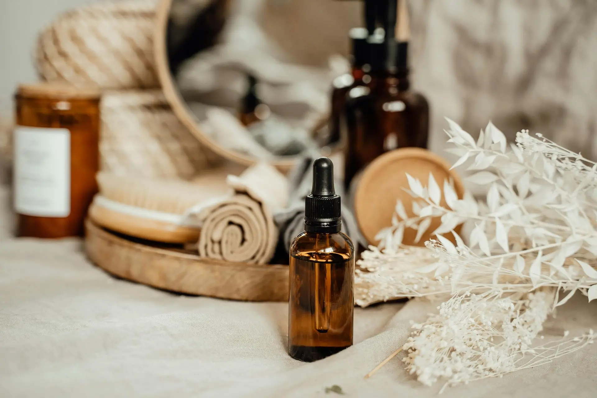 Amber dropper bottle with spa essentials and natural décor.
